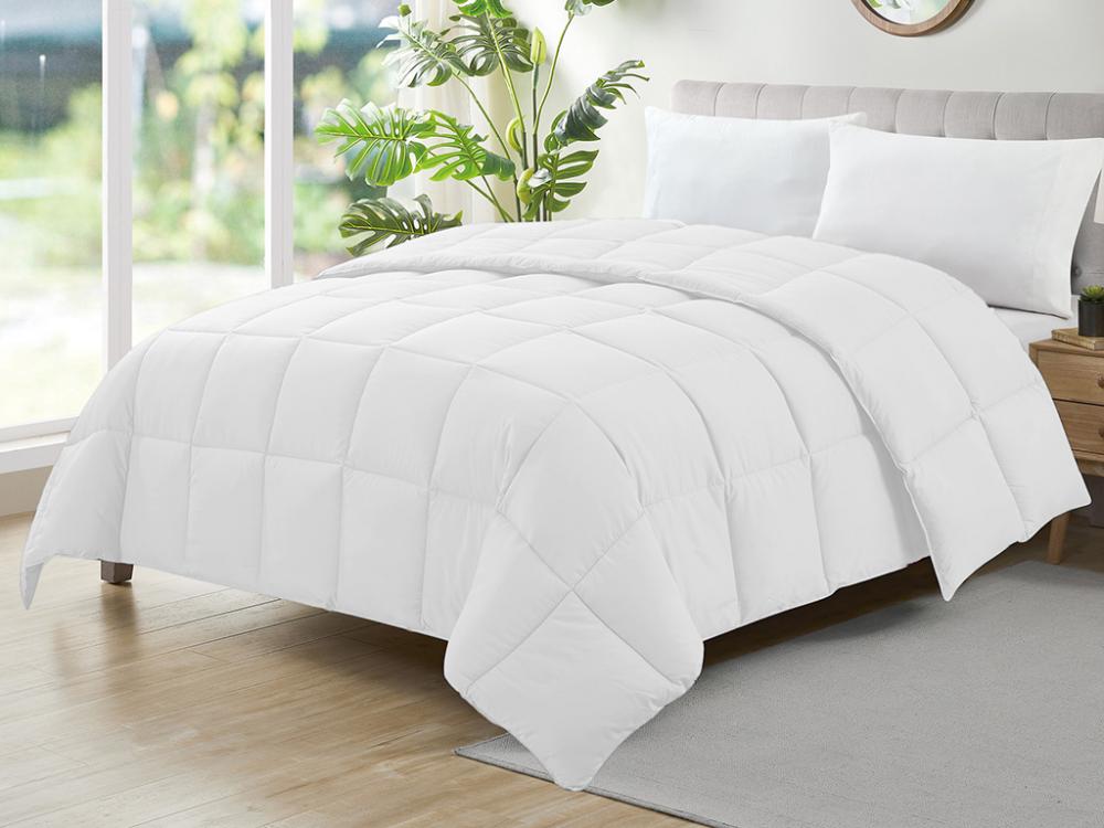 Edredom Ecopluma branco da Camesa sobre uma cama de casal, com costuras em quadrados